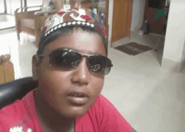 a young boy wearing sunglasses and a crown