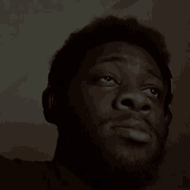 a man with headphones on his head looks up at the sky