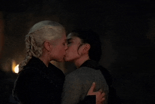 a couple of women are kissing in the dark .