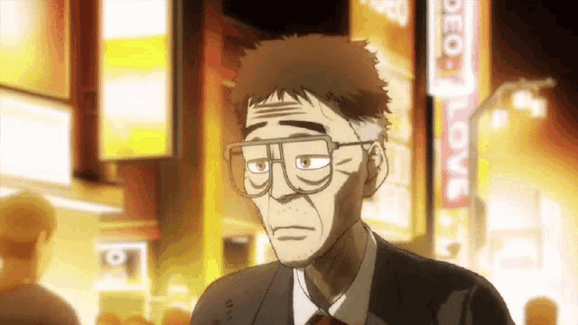 a man wearing glasses is standing in front of a sign that says love