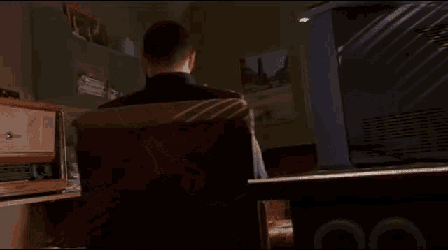 a man is sitting in a chair in front of a tv .