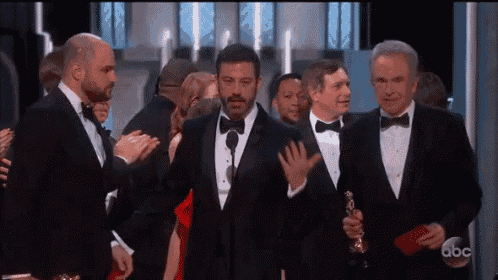 a group of men in tuxedos and bow ties are standing in front of a microphone at an awards show sponsored by abc