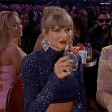 a woman in a blue top is holding a glass of water