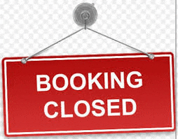 a red sign that says `` booking closed '' is hanging from a hook on a window .