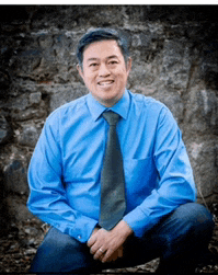 a man in a blue shirt and tie is kneeling down