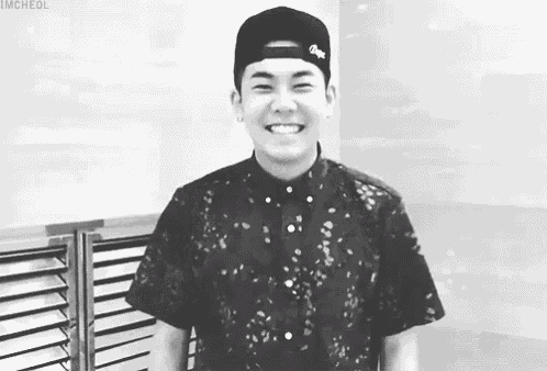 a young man wearing a baseball cap and a floral shirt is smiling .