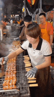 a woman is cooking food on a grill while wearing an apron that says ' shanghai city ' on it