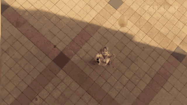 a person 's shadow is cast on a brick floor