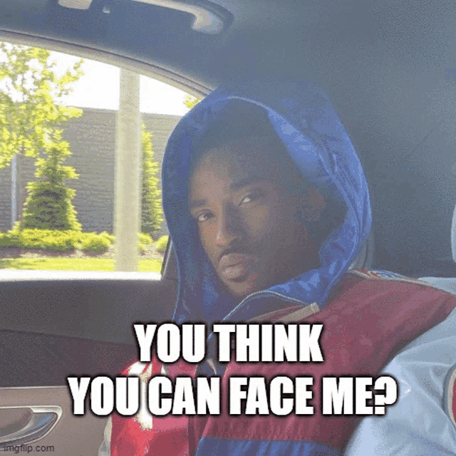 a man wearing a hooded jacket is sitting in a car with the caption " you think you can face me "