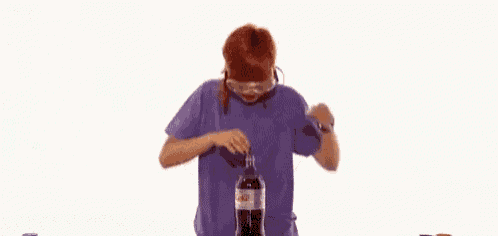 a man is standing in front of a bottle of coke .