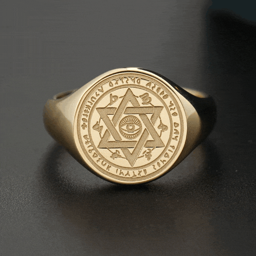 a gold ring with an all seeing eye in the center and a circle around it that says ' ihaild '