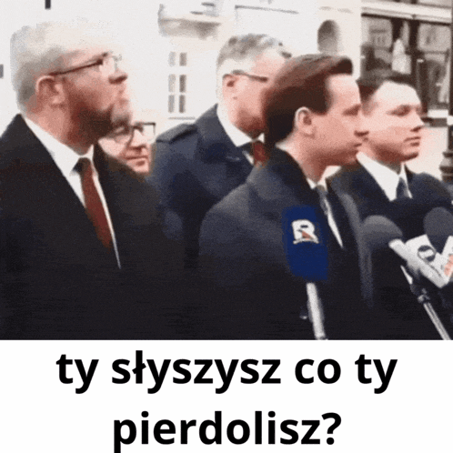 a group of men standing in front of microphones with the words ty slyszysz co ty pierdolisz on the bottom