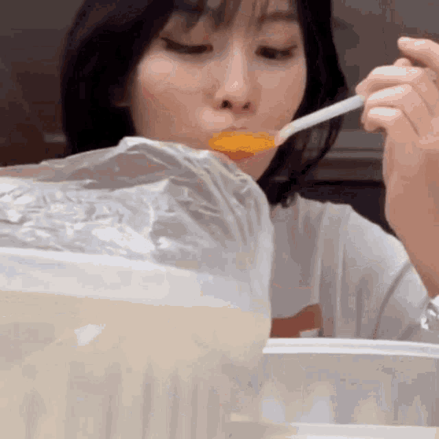 a woman is eating food from a plastic bag with a spoon ..