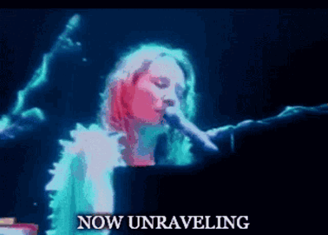 a woman is singing into a microphone with the words now unraveling below her