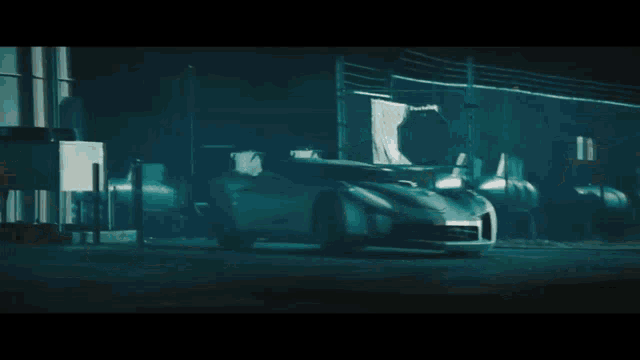 a robot is riding a motorcycle down a city street at night
