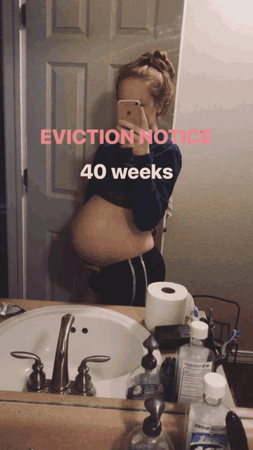 a pregnant woman is taking a selfie in front of a mirror with the words " eviction notice 40 weeks "