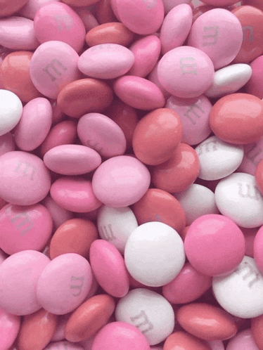 a pile of pink and white m & m candies