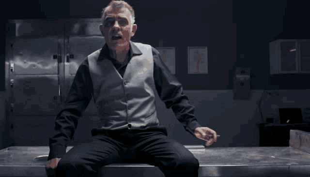 a man is laying on a table with his feet up and a sign that says ' a ' on it