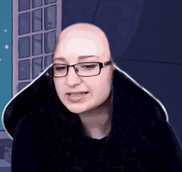 a bald woman wearing glasses and a black shirt