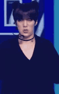 a close up of a young man wearing a choker and a microphone .