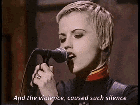 a woman singing into a microphone with the words `` and the violence , caused such silence '' .