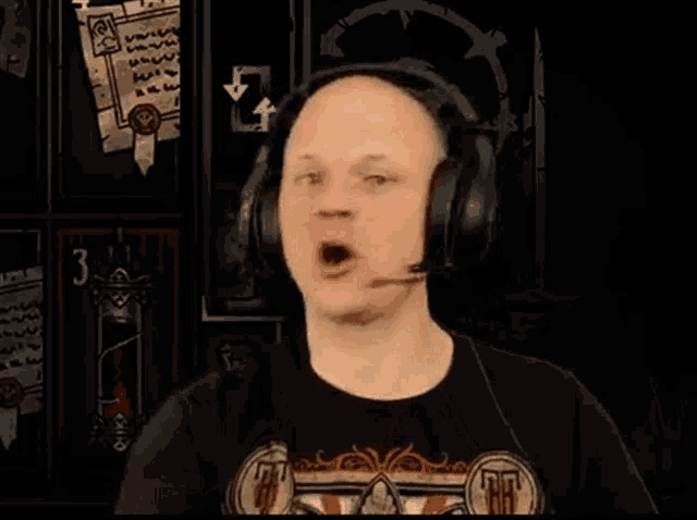 a bald man wearing headphones with a microphone on his head