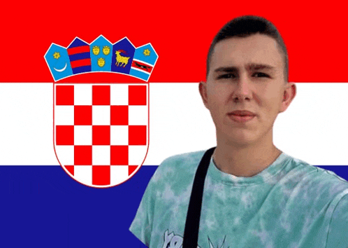 a young man stands in front of a flag with a coat of arms