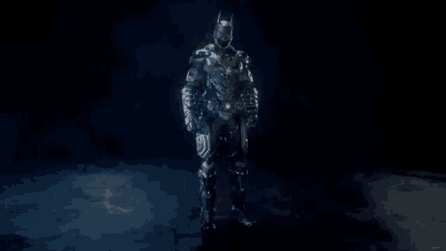 a superhero in a black suit is standing in the dark .