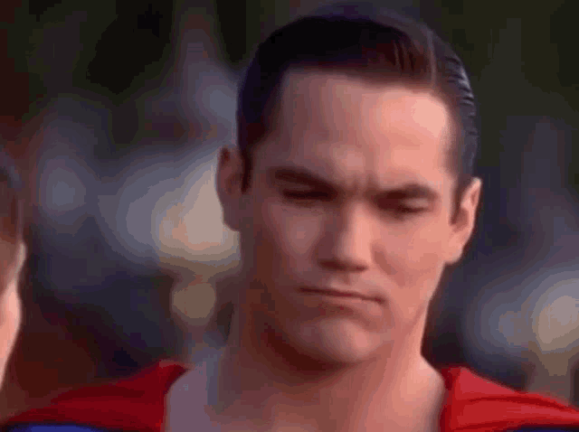 a close up of a man in a superman costume making a face .