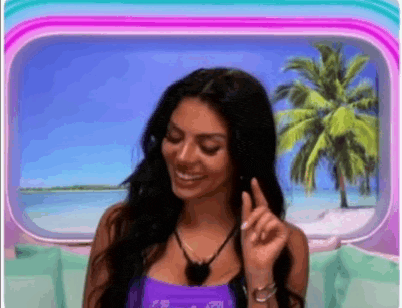 a woman is standing in front of a window with a palm tree in the background and smiling .