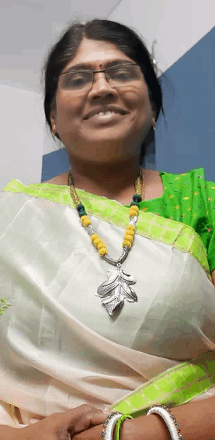 a woman wearing glasses and a necklace with yellow beads smiles for the camera