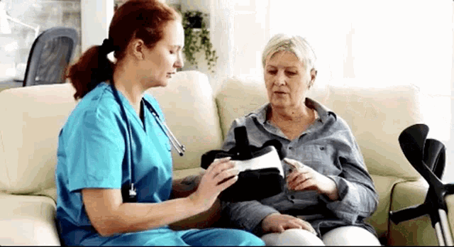 a nurse is sitting on a couch talking to an elderly woman who is wearing a virtual reality headset .