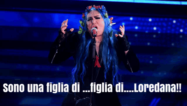 a woman with blue hair singing into a microphone with the words sono una figlia di figlia di loredana written below her