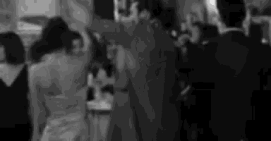 a black and white photo of people dancing at a party .