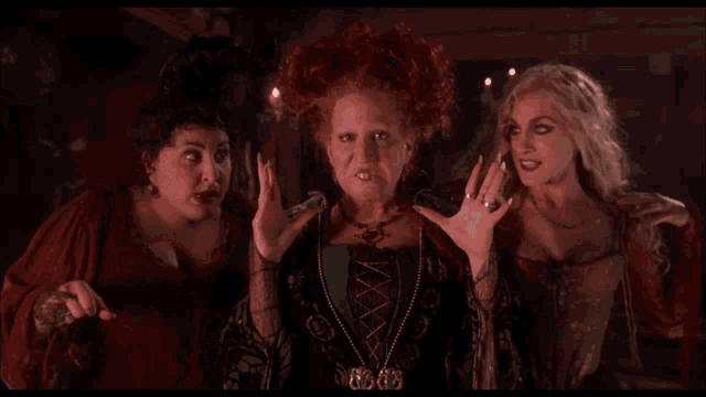 three women are standing next to each other and one of them is wearing a necklace that says ' sally ' on it