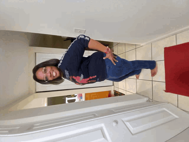 a woman wearing a shirt that says ' guess ' on it is standing in a hallway