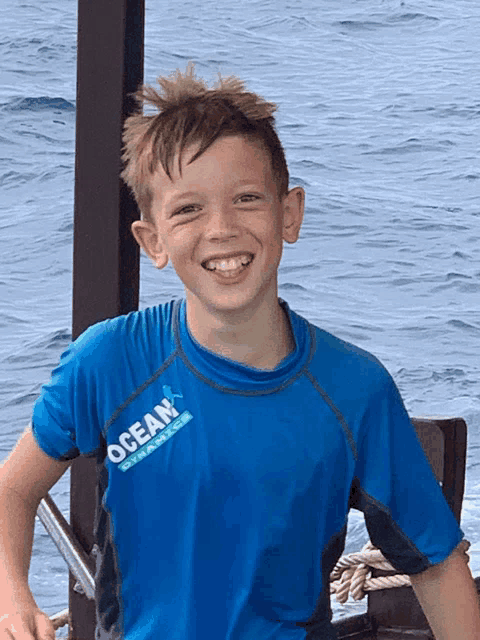 a young boy wearing a blue ocean dynamics shirt