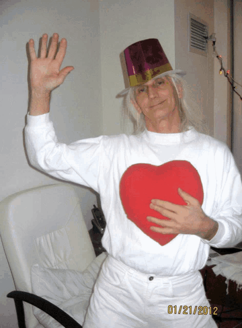 a man wearing a top hat and holding a red heart has a picture taken on 01/21/2012