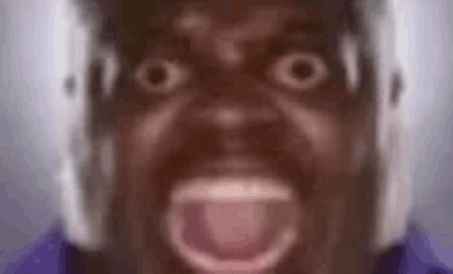a close up of a man 's face with his mouth open and headphones on his head .