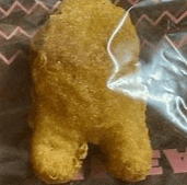 a chicken nugget that looks like a teddy bear is in a plastic bag .