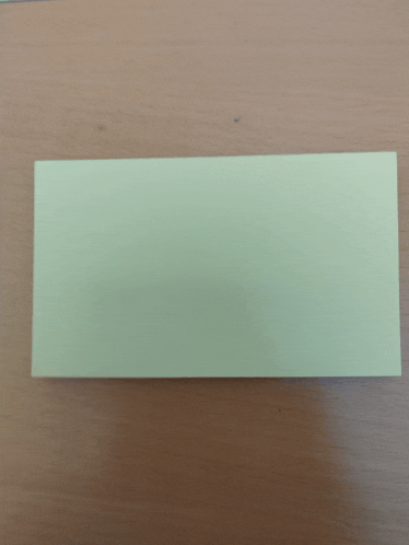 a rectangular piece of paper is on a wooden table