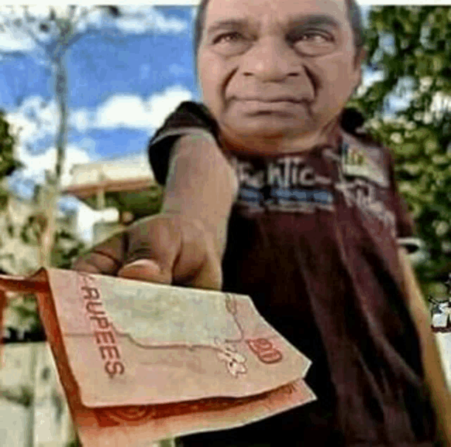 a man is holding a few rupees in his hand .