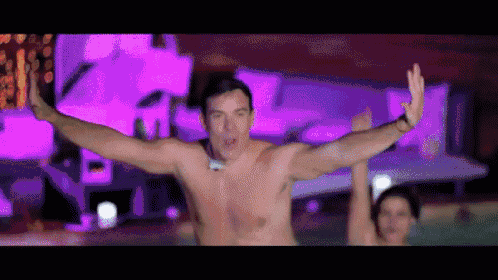 a shirtless man is dancing in a pool with a woman