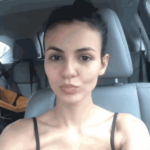 a woman without makeup sits in a car