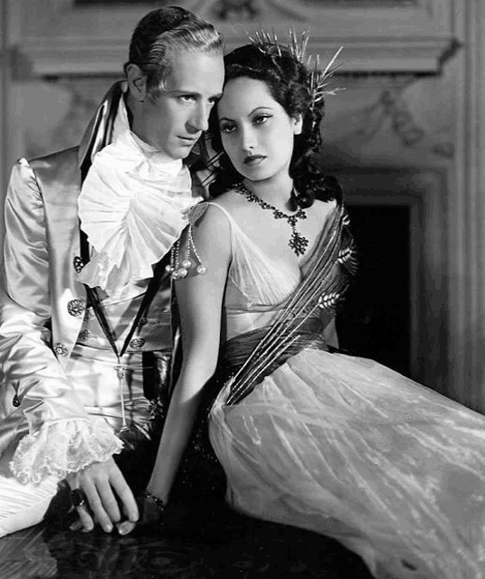 a black and white photo of a man and a woman sitting next to each other