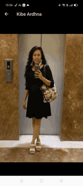 a woman taking a picture of herself in an elevator with the name kibe ardhna