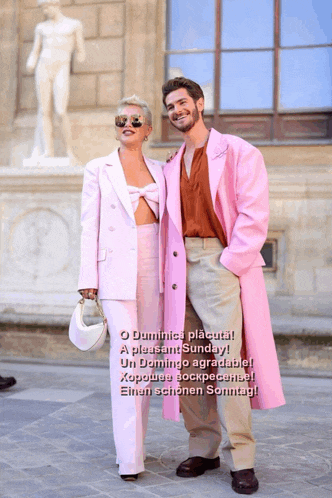 a man in a pink coat stands next to a woman in a pink outfit