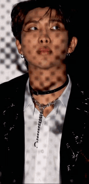 a close up of a man wearing a choker and a white shirt