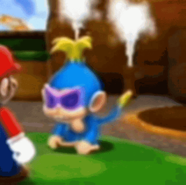 a blue monkey wearing sunglasses and a mask is sitting on the grass next to a mario .