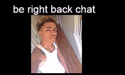 a young man is taking a selfie in a hallway with the words be right back chat above him .